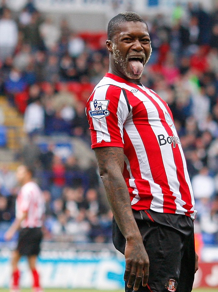 a man wearing a red and white striped shirt with the word boy on it