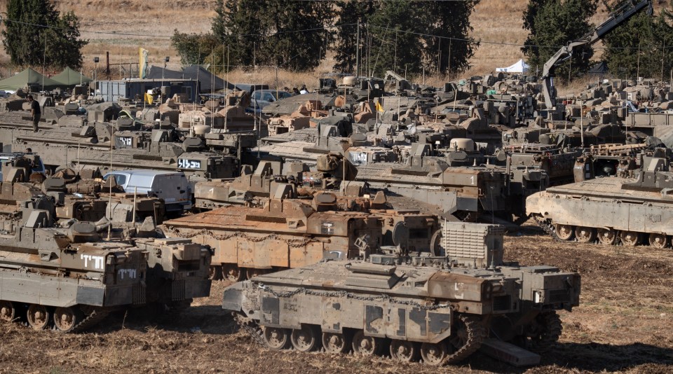 a bunch of military vehicles are parked in a field