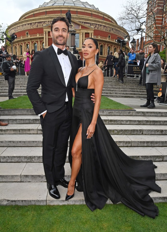 a man in a tuxedo stands next to a woman in a black dress