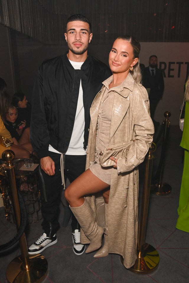 a man and a woman pose for a picture in front of a sign that says rett