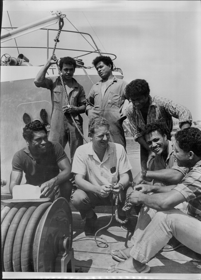 a black and white photo of a group of men on a boat