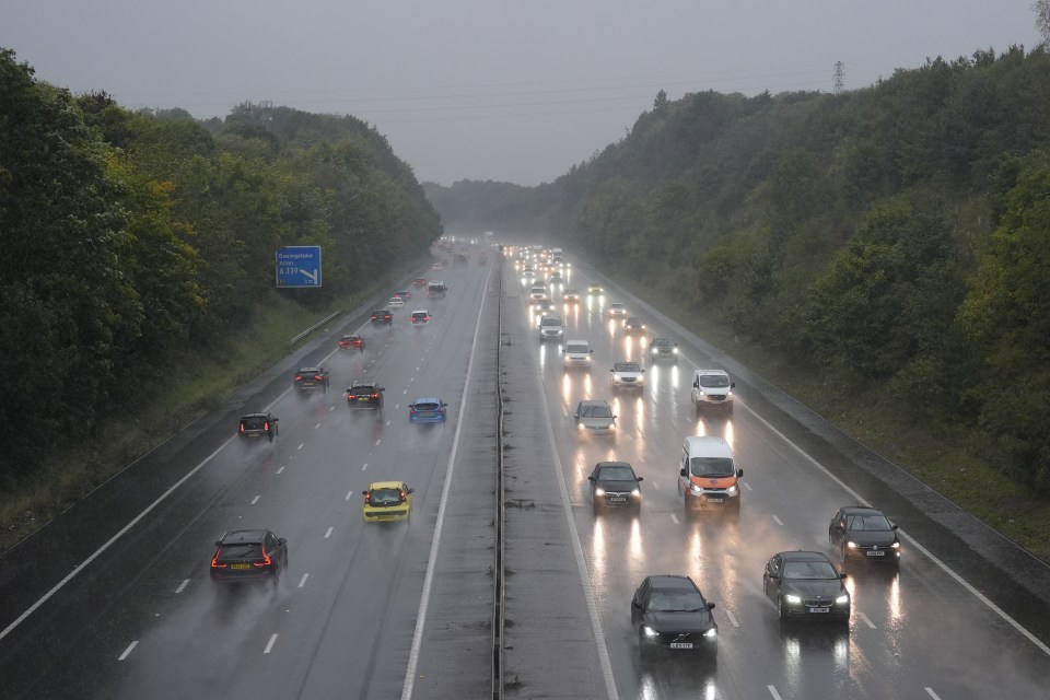 cars are driving down a highway with a sign pointing to the right