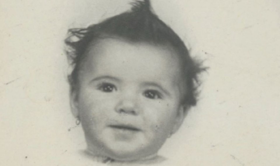 a black and white photo of a baby with a mohawk