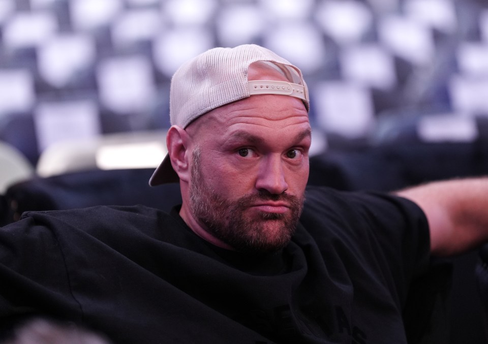 a man wearing a black shirt and a white hat looks at the camera