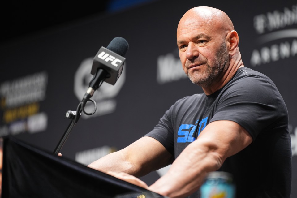 a man in a ufc shirt stands in front of a microphone