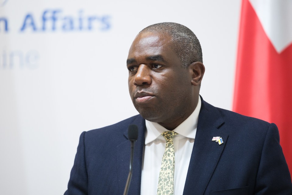 a man in a suit and tie stands in front of a sign that says affairs