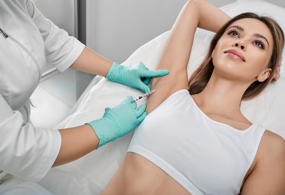 a woman is getting an injection in her armpit