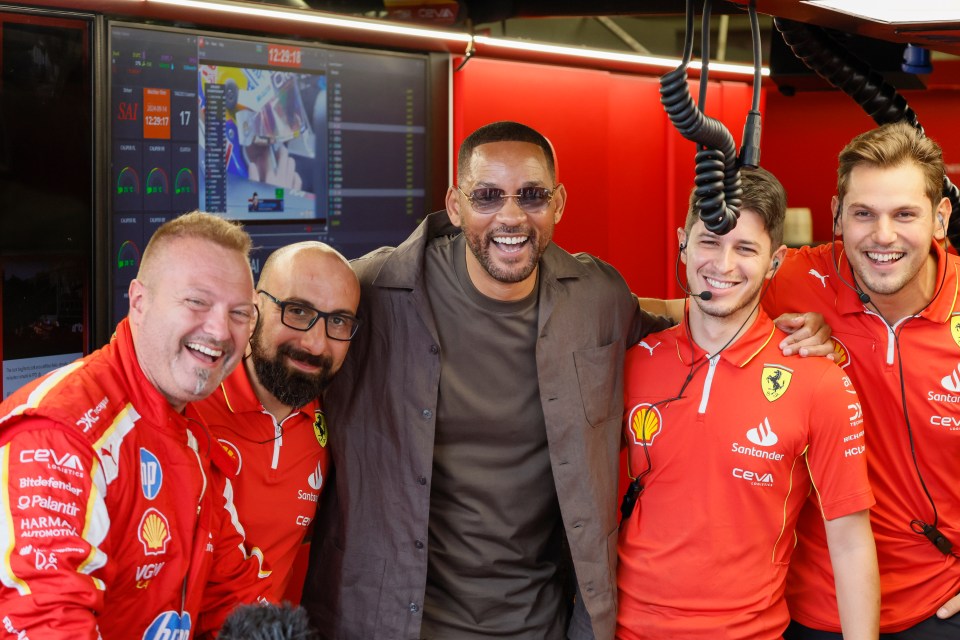 a group of men posing for a picture with one wearing a santander shirt