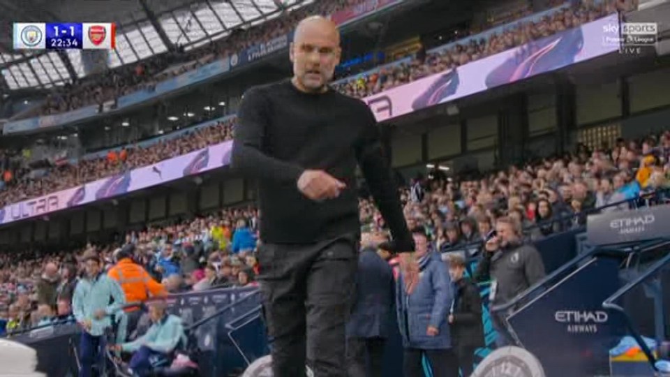 a man in a black shirt is standing in front of a crowd at a soccer game .