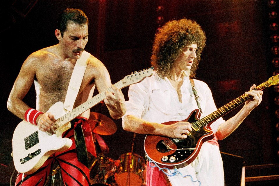 freddie mercury and queen playing guitars on stage