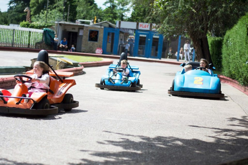 a girl in an orange go kart with the number 2 on it