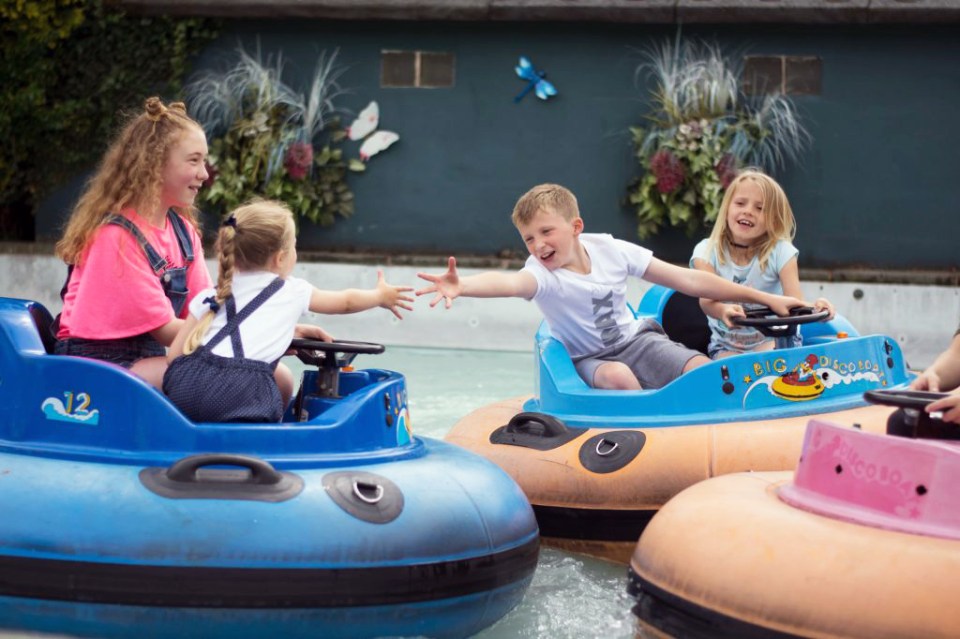 a group of children are riding bumper boats with the number 12 on them