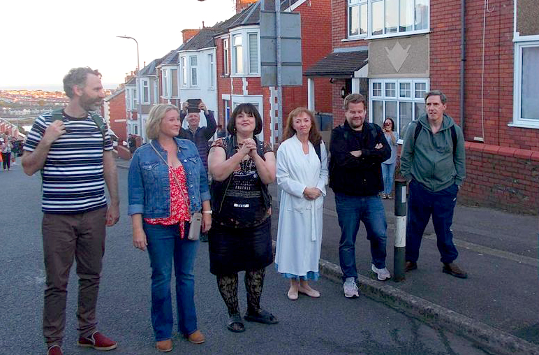 a group of people standing on the side of a road