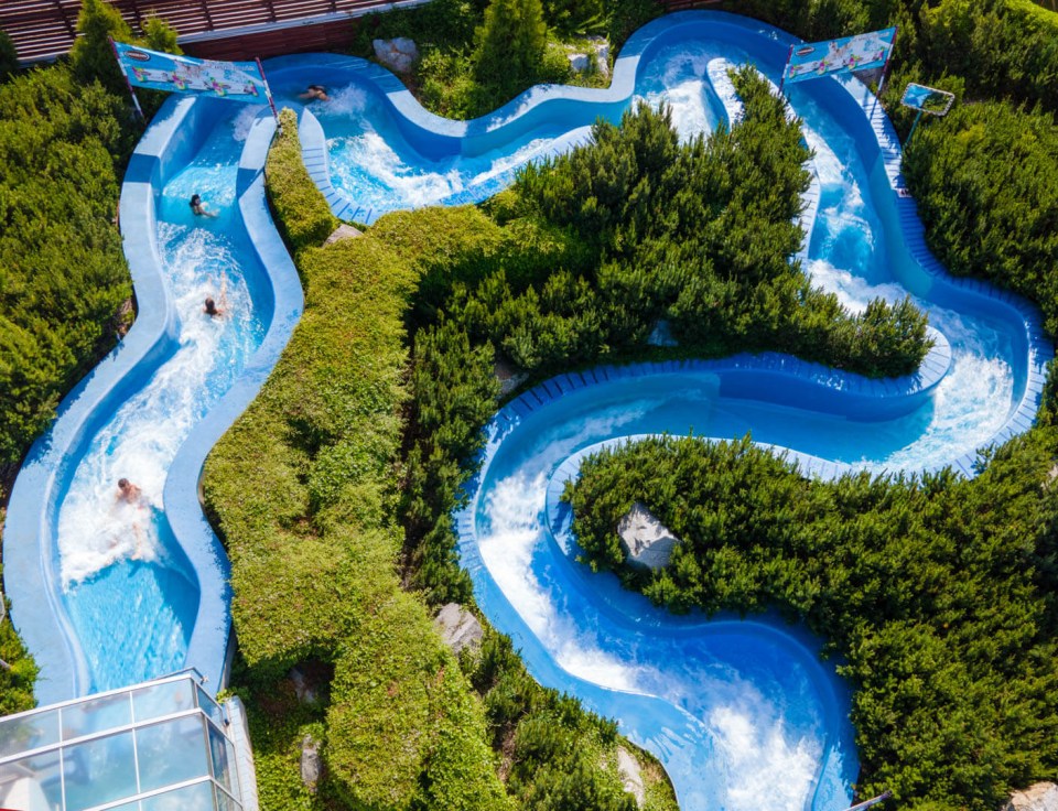 a man is going down a water slide at a water park