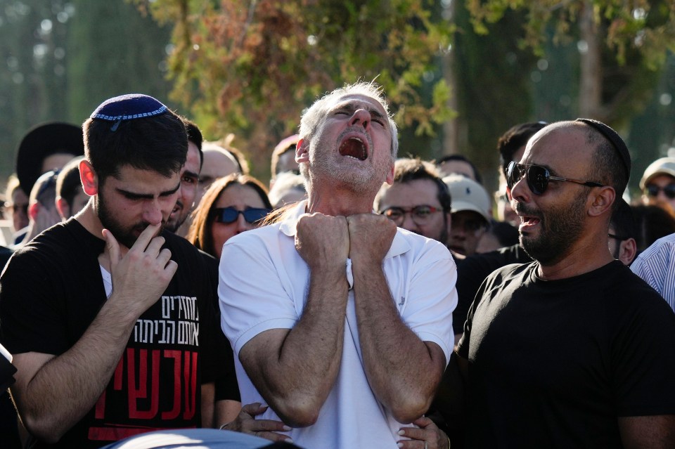 Yigal Sarusi, centre, mourns during the funeral of his son, slain hostage Almog Sarusi, who was killed in Hamas captivity in the Gaza Strip