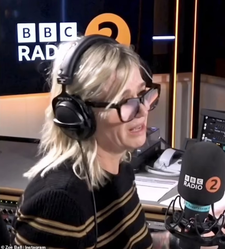 a woman wearing headphones stands in front of a bbc radio 2 microphone