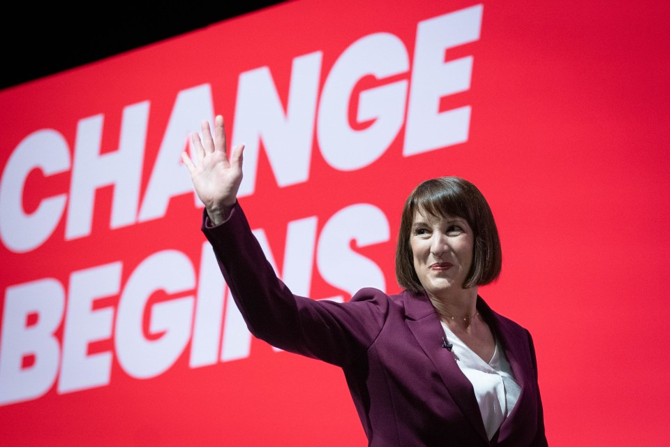 a woman stands in front of a large screen that says change begins