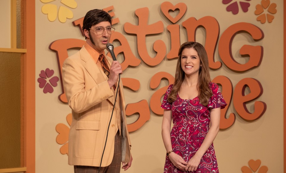 a man and a woman stand in front of a wall that says dating game