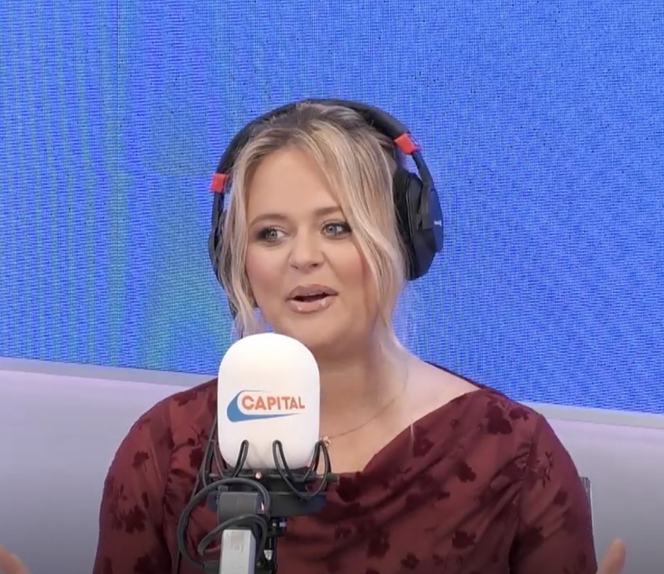 a woman wearing headphones is talking into a capital microphone