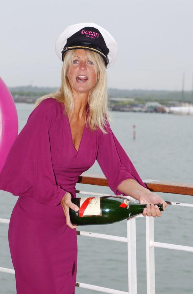 a woman wearing an ocean cruises hat holds a bottle of champagne