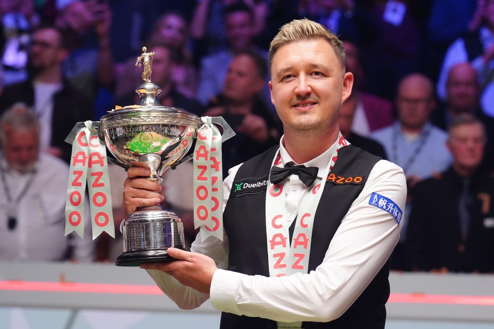 a man holding a trophy that says ' snooker ' on it