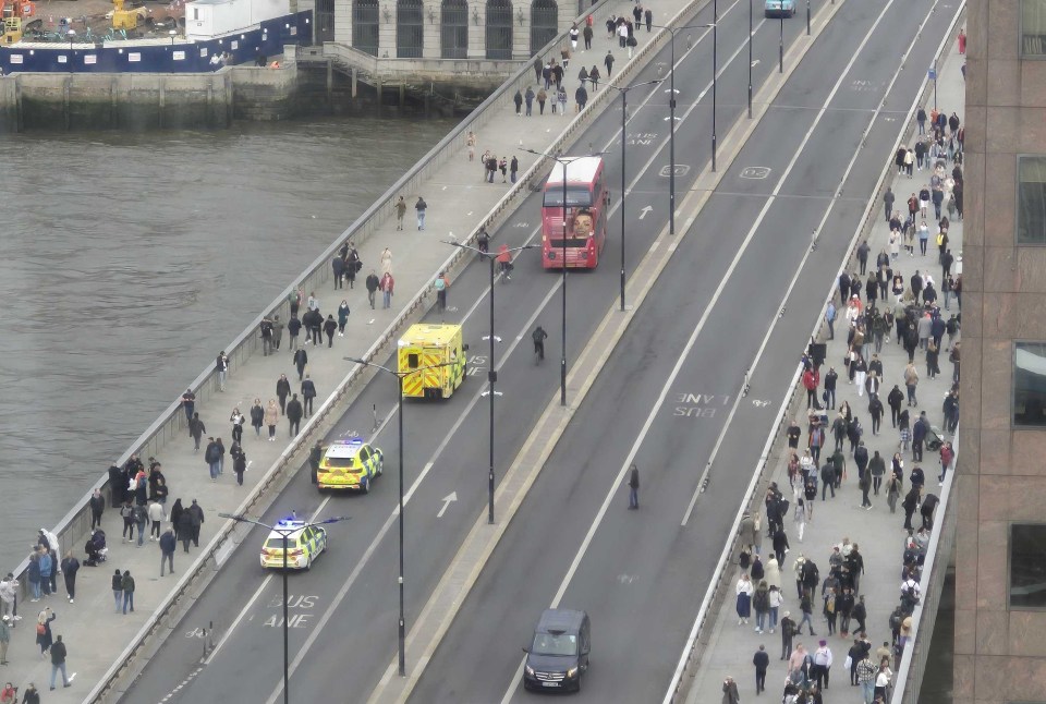 a red double decker bus is driving down a busy street