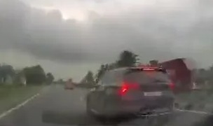 a car is driving down a highway in the rain .