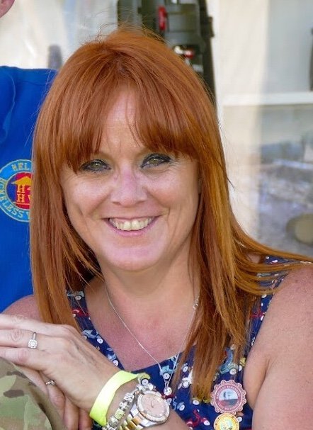 a woman with red hair is smiling and wearing a watch