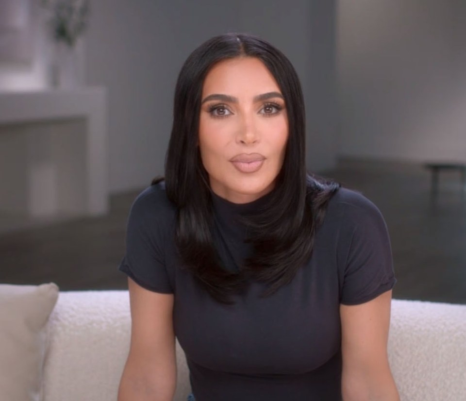 a woman in a black shirt is sitting on a couch