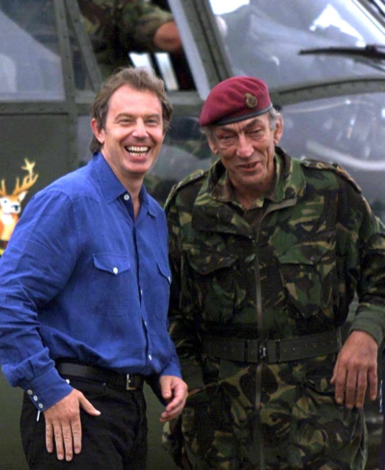 two men in military uniforms are standing next to each other and smiling