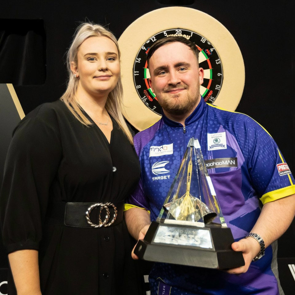 a man in a target shirt holds a trophy next to a woman