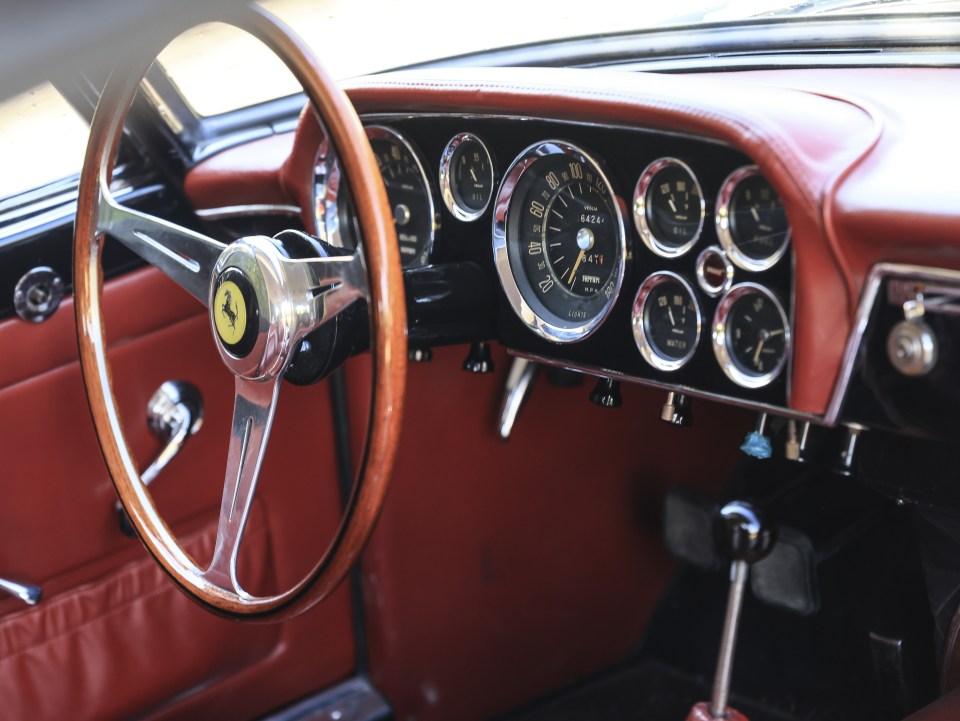 a dashboard of a ferrari with a speedometer that reads 64 km / h