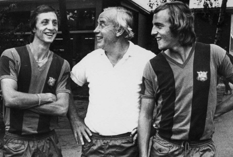 three men standing next to each other with one wearing a shirt that says ' fc barcelona ' on it