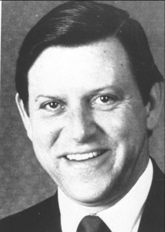 a man in a suit and tie smiles for the camera