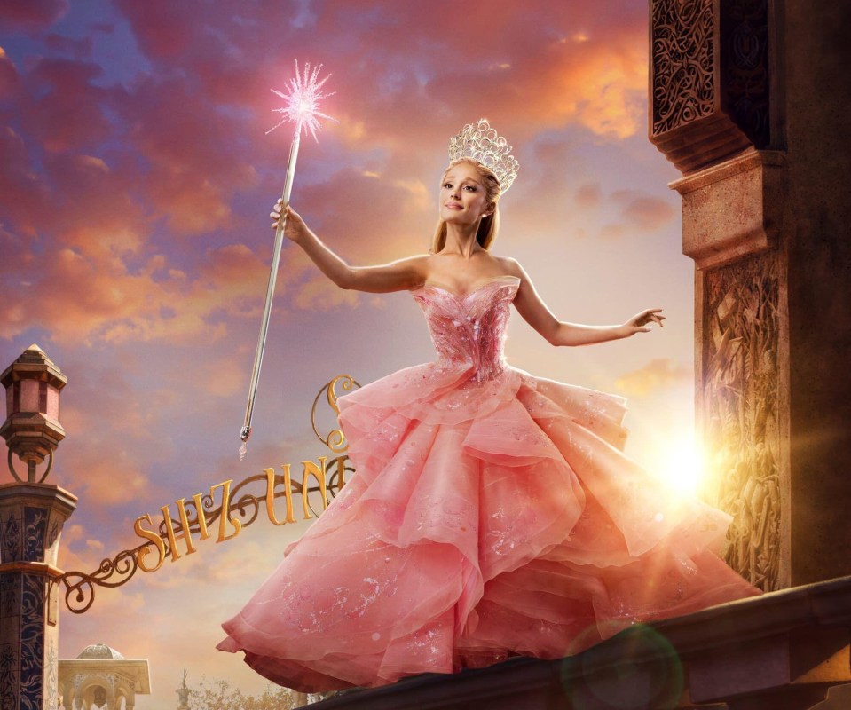 a woman in a pink dress is holding a wand with the word silly on it