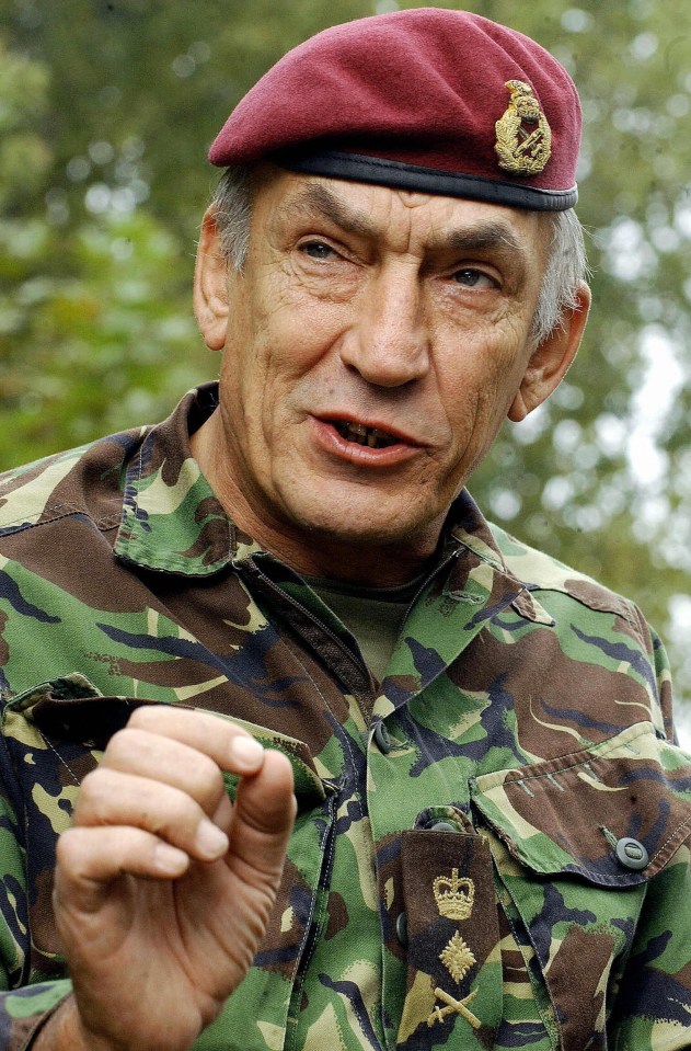 a man in a military uniform is wearing a red beret