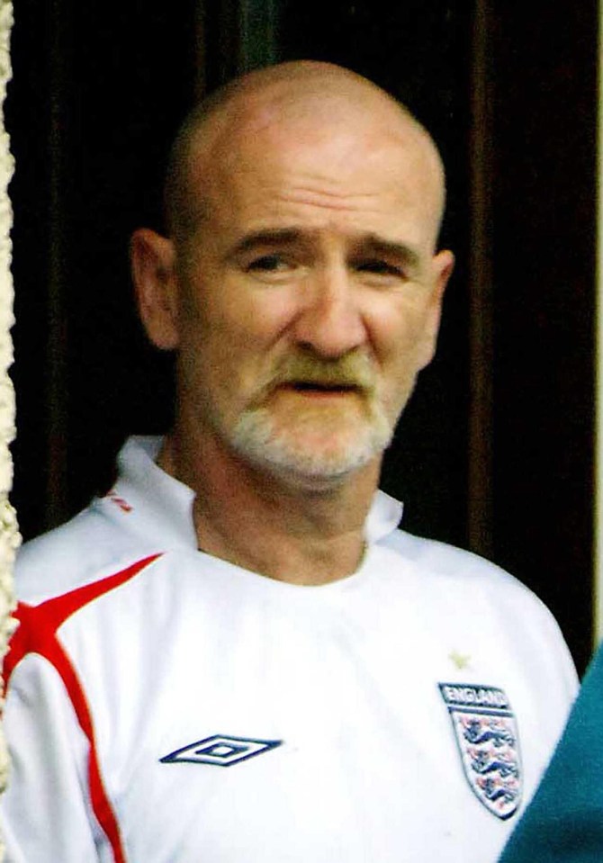 a bald man with a beard is wearing a white england jersey