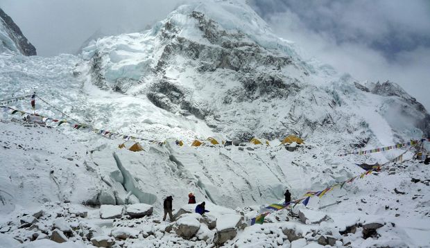 a snowy mountain covered in flags and tents