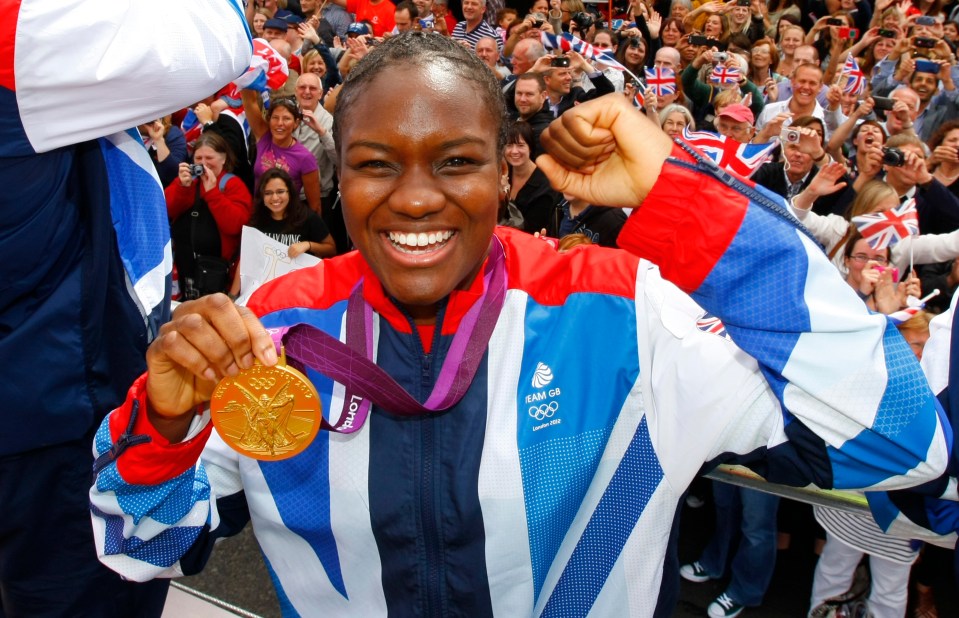 a woman holding a gold medal with the word london on it