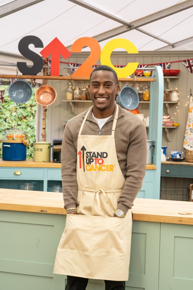 a man wearing an apron that says stand up to cancer