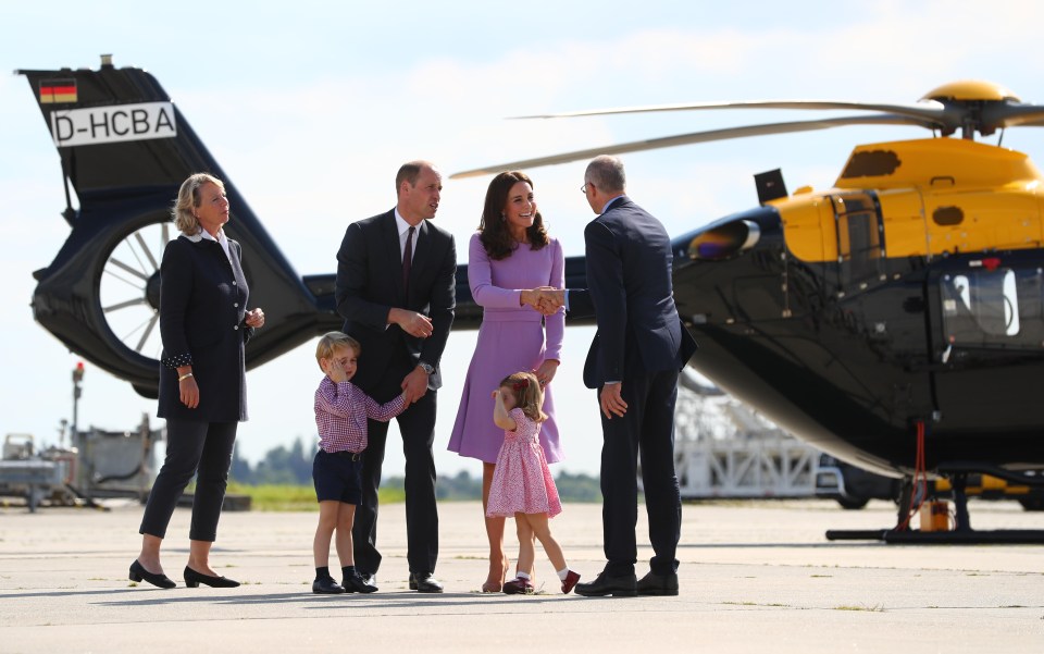 a group of people standing in front of a helicopter with d-hcba on the tail