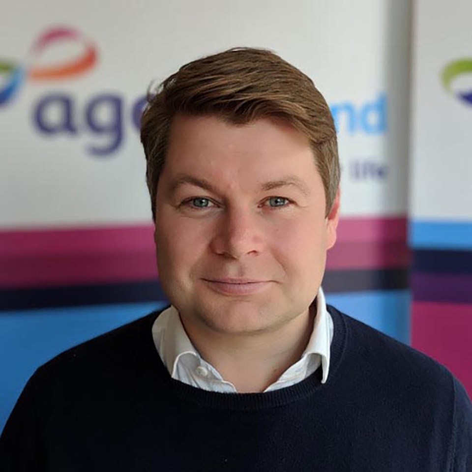 a man stands in front of a sign that says ag