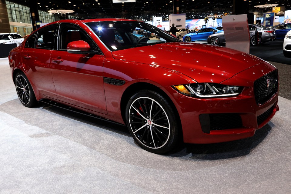 a red jaguar is on display at a car show