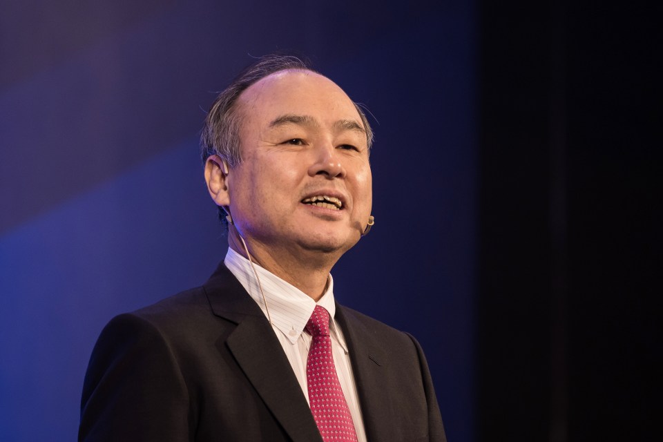 a man in a suit and tie is speaking into a microphone