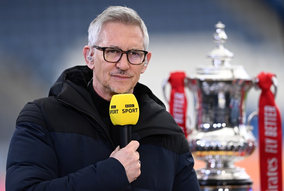 a man holding a bbc sport microphone in front of a trophy