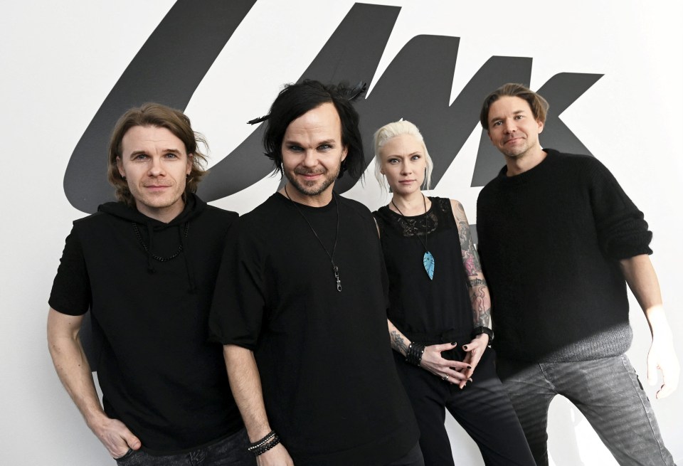 a group of people standing in front of a sign that says uk