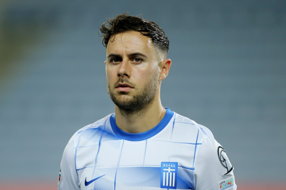 a man wearing a white and blue jersey with the word greece on it