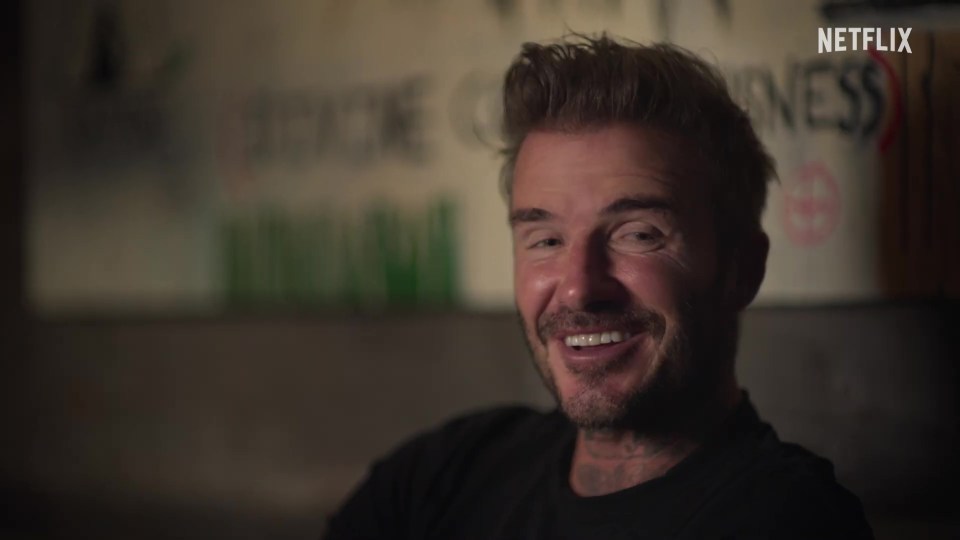 a man is smiling in front of a sign that says netflix