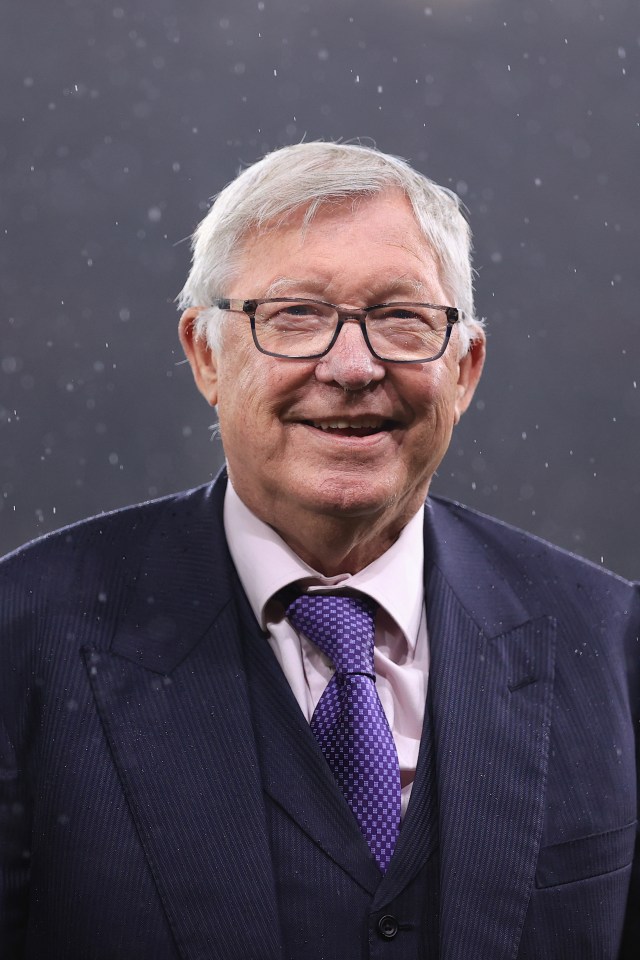 a man wearing glasses and a suit smiles for the camera