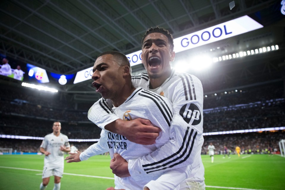 two soccer players are celebrating in front of a sign that says goool